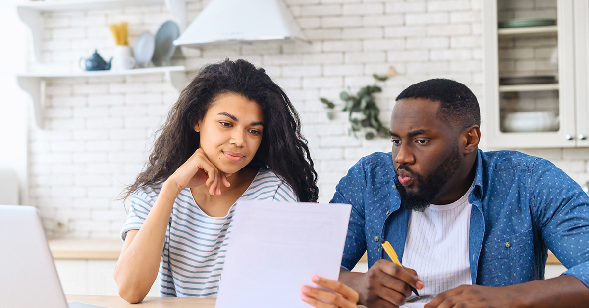 A couple reviews their budget in the kitchen