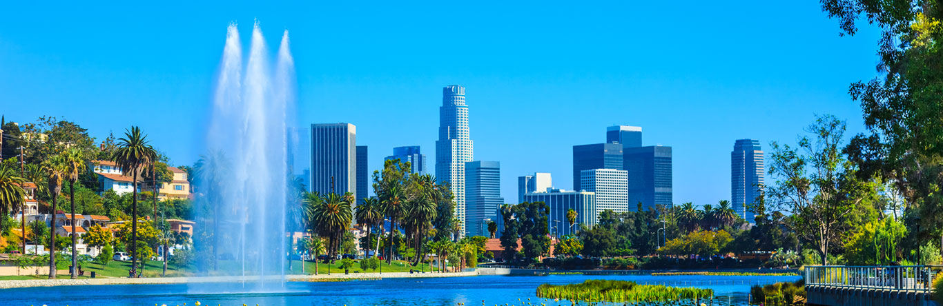 city skyline behind fountain in river