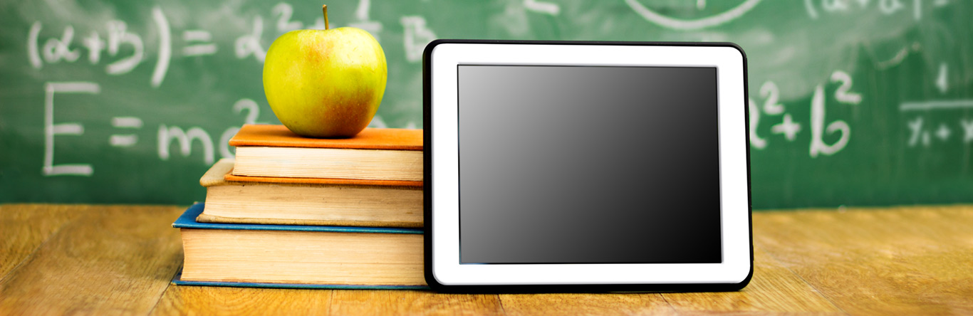 Education green apple on 3 books next to tablet